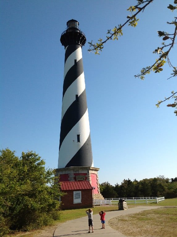 Two Boys Looking Up at a Lighthouse